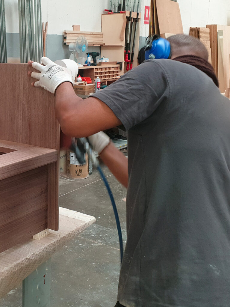 Artigiano al lavoro su arredi in legno per interni di barche di lusso
